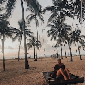 Girl on swing on tropical beach in Fiji