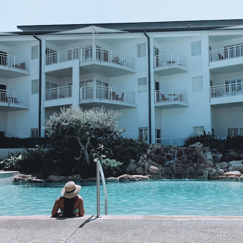 Girl and floatie in pool with palm